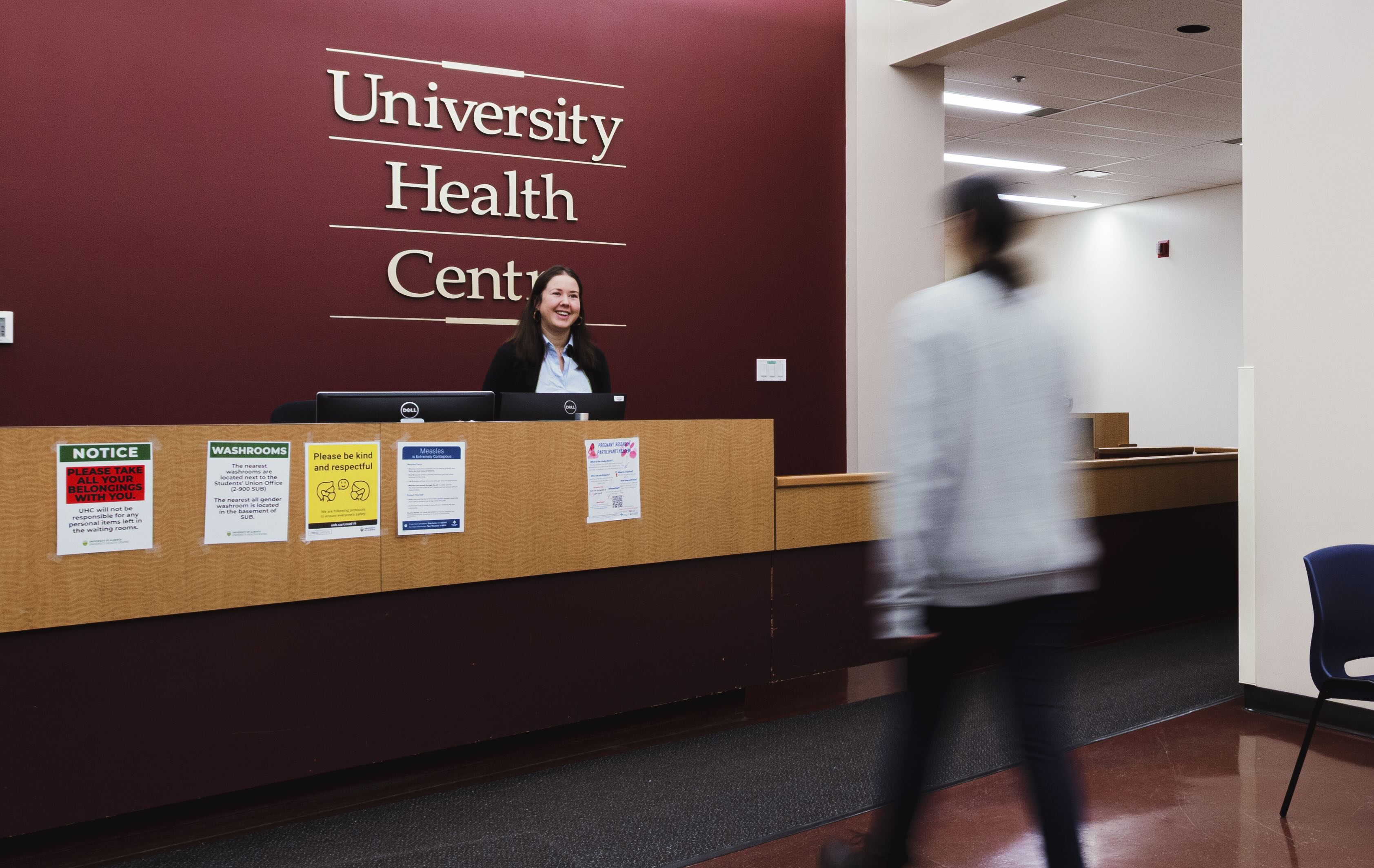 University Health Centre receptionist welcomes a patient at the main desk