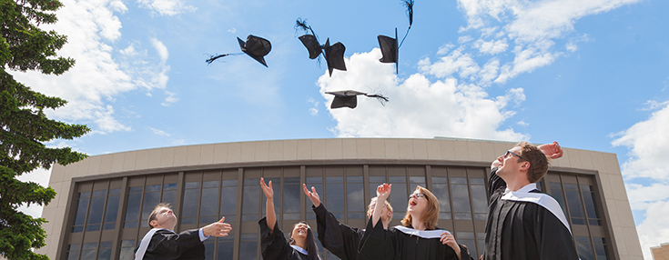 graduate students throwing hats in the air